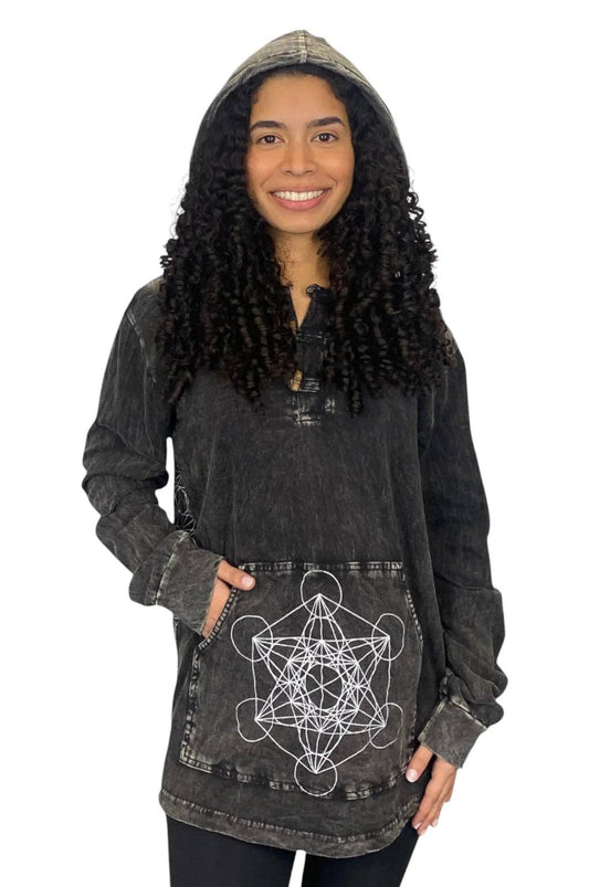 A woman wearing a dark gray acid-wash hooded tunic top with a white geometric star of Metatron's Key design on the front pocket, set against a plain white background.
